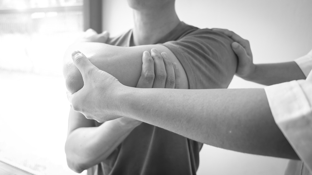 Therapist treating a male injured by rotator cuff stretching method, Physical therapy concept.